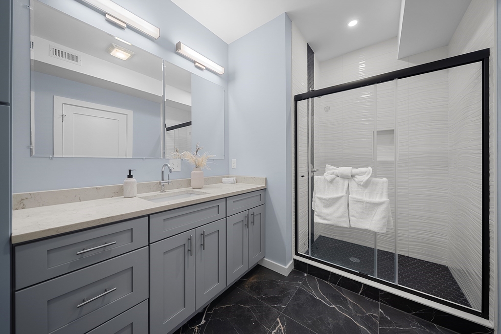 175 Howard Avenue, Unit 2 Boston, MA 02125 - Photo 20 of 26 a bathroom with a shower sink and mirror