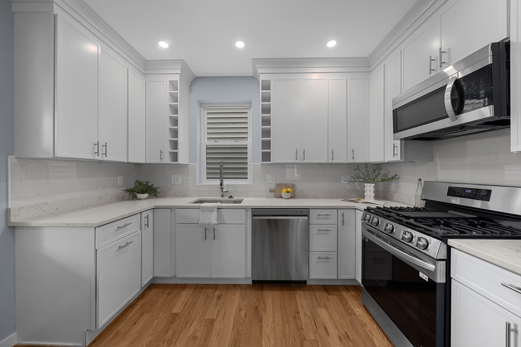 175 Howard Avenue, Unit 2 Boston, MA 02125 - Photo 7 of 26 a kitchen with stainless steel appliances granite countertop a stove a sink and a microwave