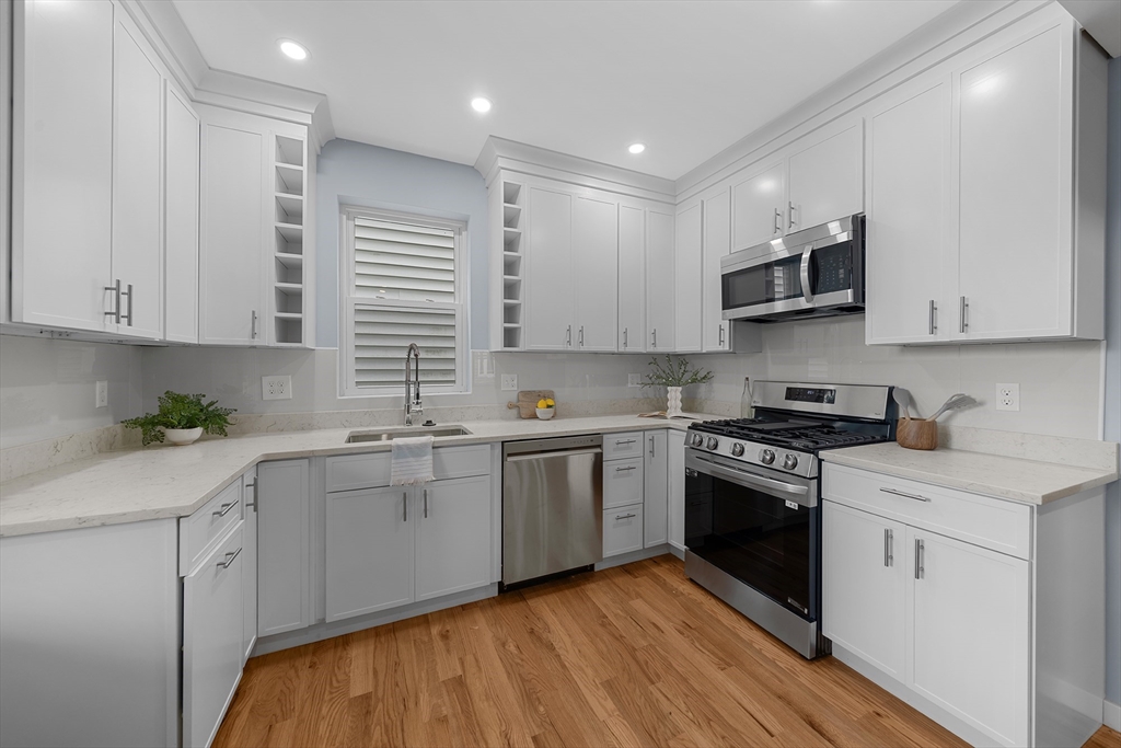 175 Howard Avenue, Unit 2 Boston, MA 02125 - Photo 9 of 26 a kitchen with stainless steel appliances granite countertop a stove top oven a sink and white cabinets