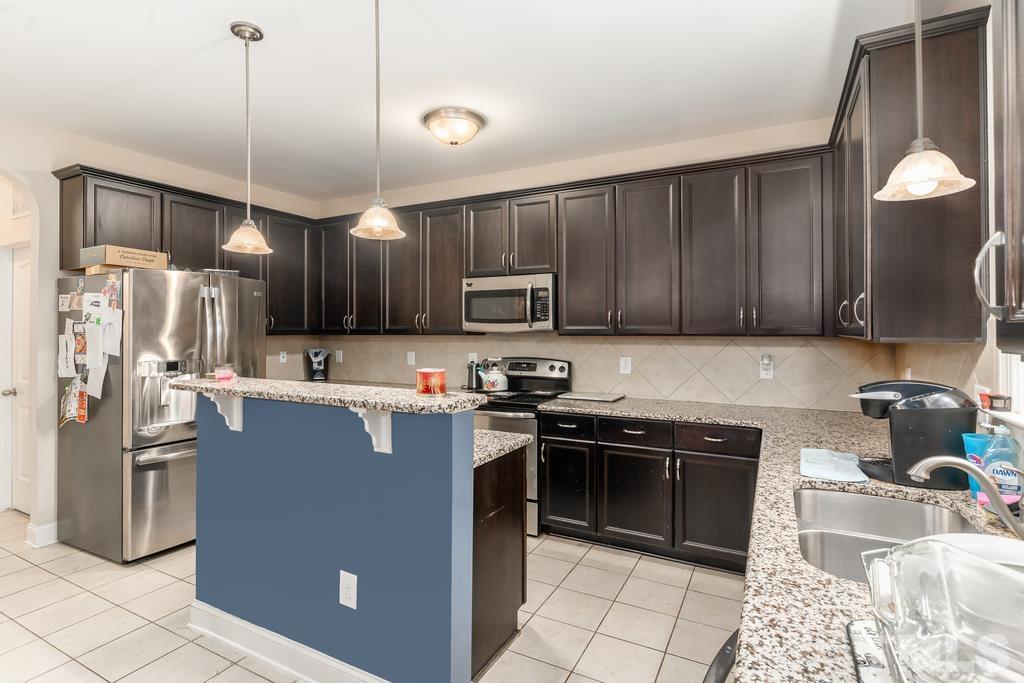 40 Cromwell Circle Cameron, NC 28326 - Photo 16 of 23 a kitchen with stainless steel appliances granite countertop a refrigerator a sink a stove and wooden cabinets