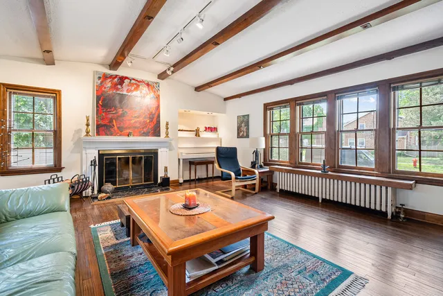a living room with furniture a fireplace and a floor to ceiling window