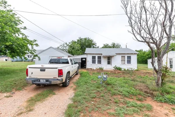 a front view of a house with a yard and trees