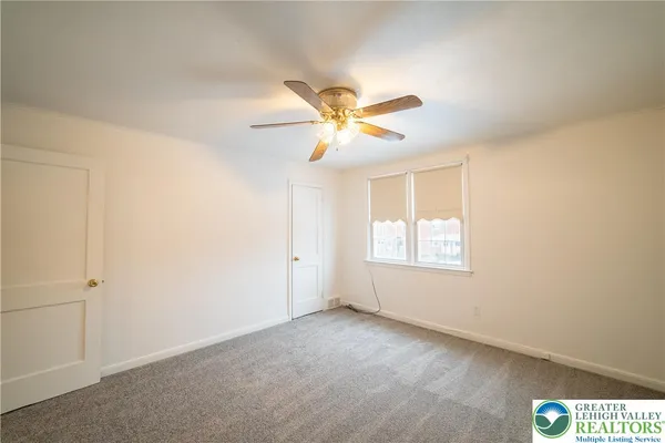 a view of room with a ceiling fan and window