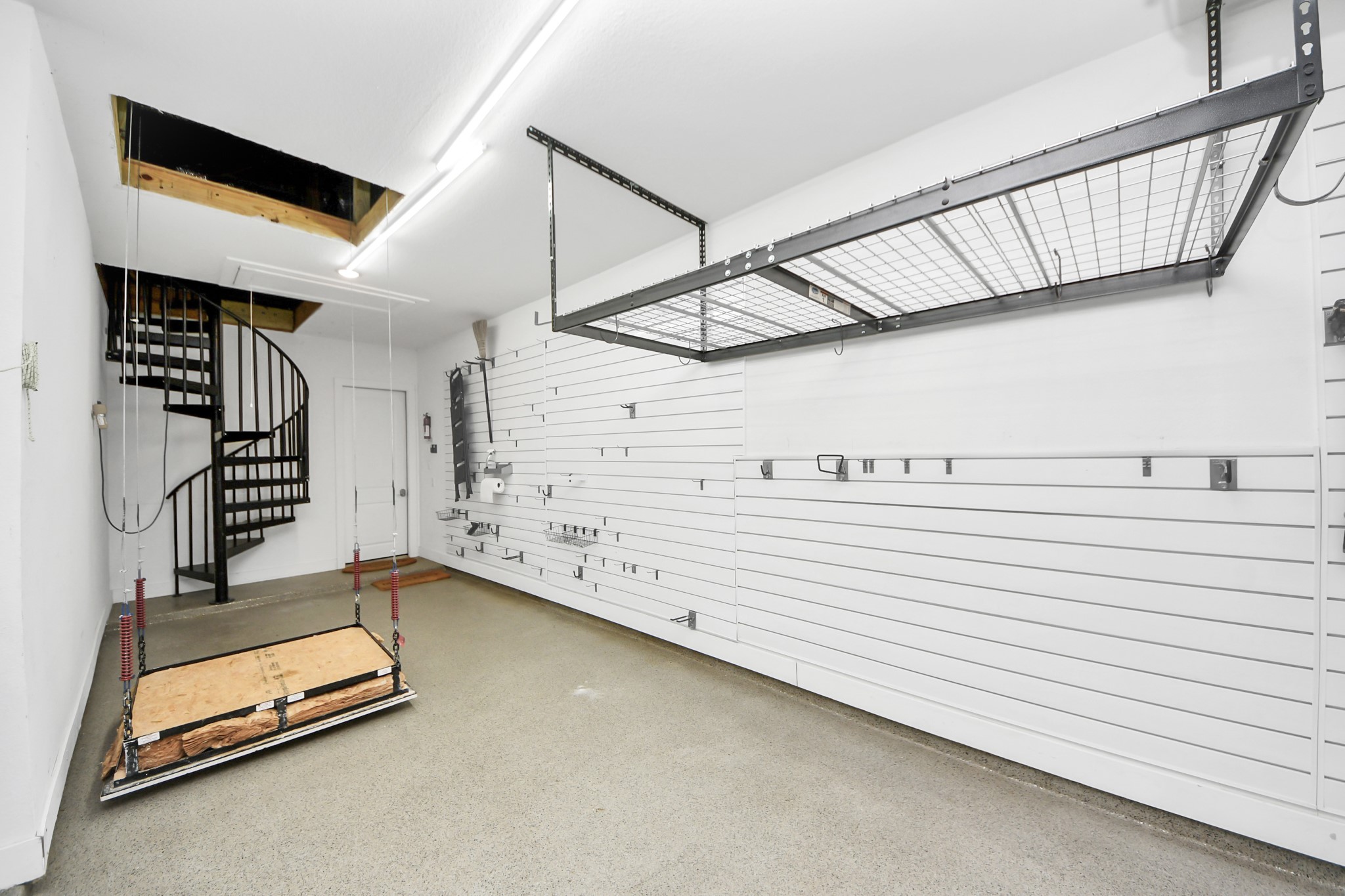 4310 Bakers Cove Manvel, TX 77578 - Photo 38 of 47 Left side shows an automated powered cargo lift system making storage of boxes much easier in the attic. A custom spiral staircase is beyond