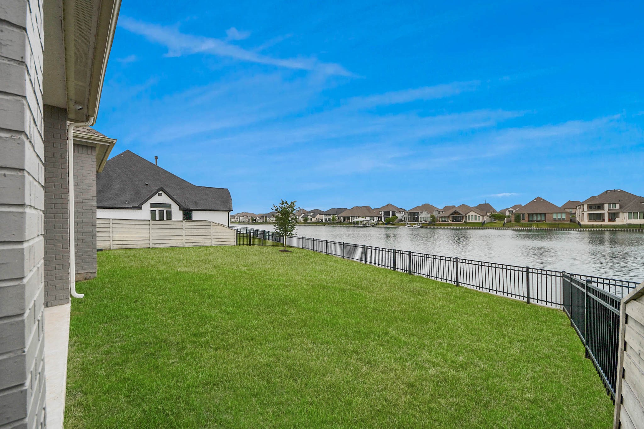 4310 Bakers Cove Manvel, TX 77578 - Photo 41 of 47 Rear view of property and adjacent easement. Private stairs to the lake are seen in the bottom right corner of the fence line.