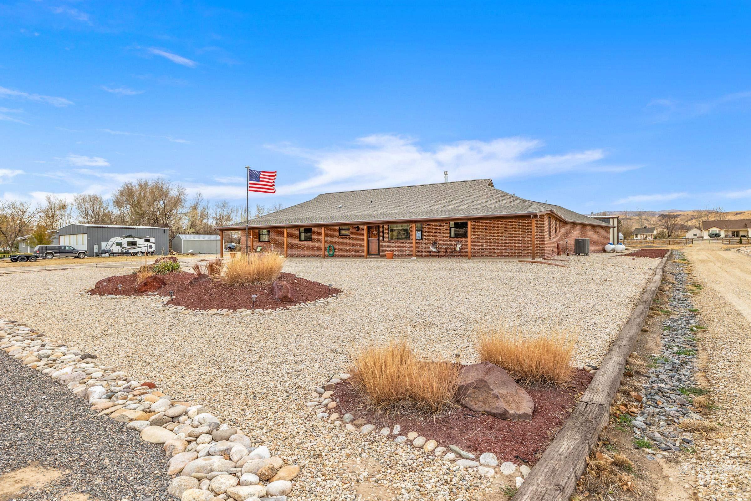 10514 Airpark Loop Road Melba, ID 83641 - Photo 32 of 47 View of property exterior featuring brick siding and a shingled roof