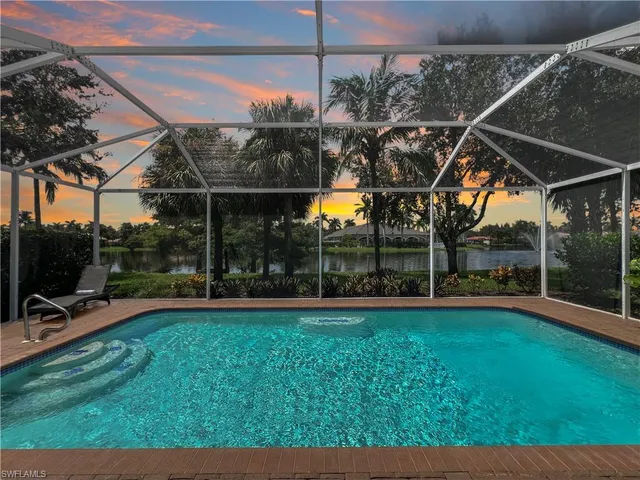 an aerial view of residential house with outdoor space and lake view in back