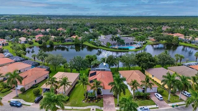 an aerial view of residential house with outdoor space and lake view in back
