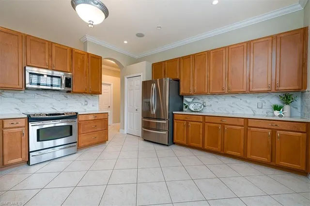 a kitchen with stainless steel appliances granite countertop a stove microwave and refrigerator