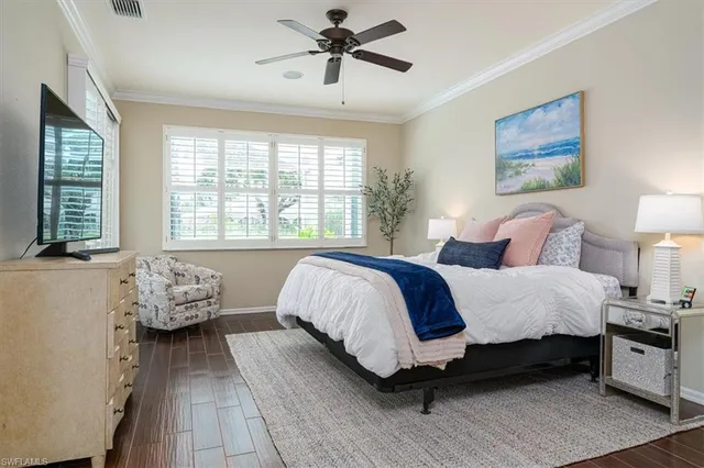 a spacious bedroom with a bed and wooden floor
