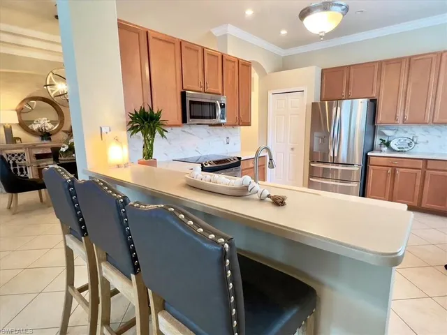 a kitchen with stainless steel appliances a sink a stove a microwave a refrigerator and cabinets