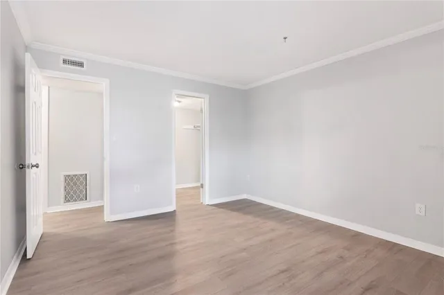 a view of an empty room with wooden floor