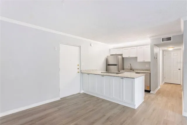 a kitchen with a sink cabinets and wooden floor