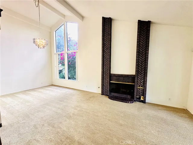 a view of an empty room with furniture and a window