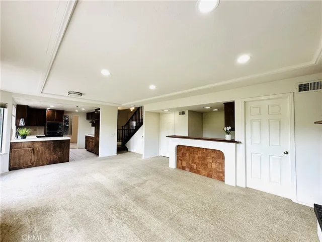 a view of an empty room with a fireplace and a window