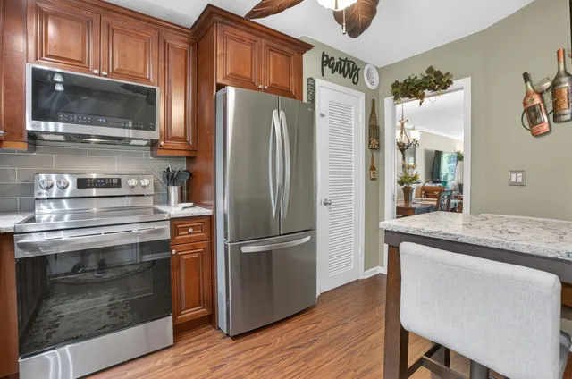 a kitchen with granite countertop a refrigerator stove and microwave