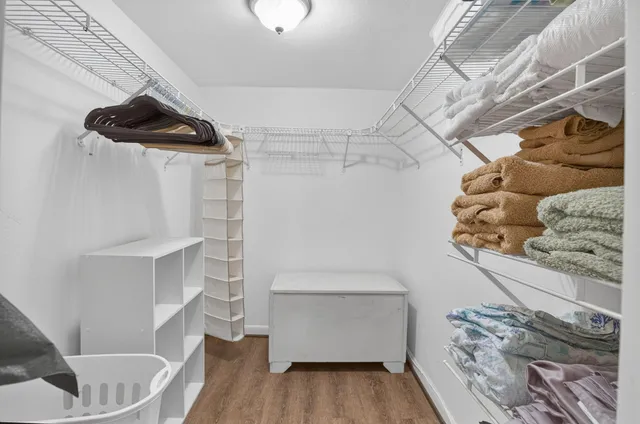 a view of walk in closet with clothes and shoes