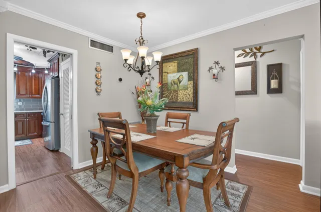 a view of a dining room with furniture wooden floor and a chandelier