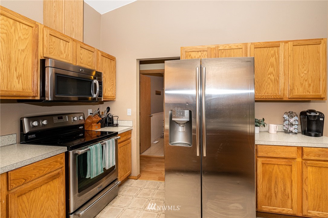 18036 Daryl Lane Southwest Rochester, WA 98579 - Photo 19 of 40 a kitchen with stainless steel appliances granite countertop a stove a refrigerator and a microwave
