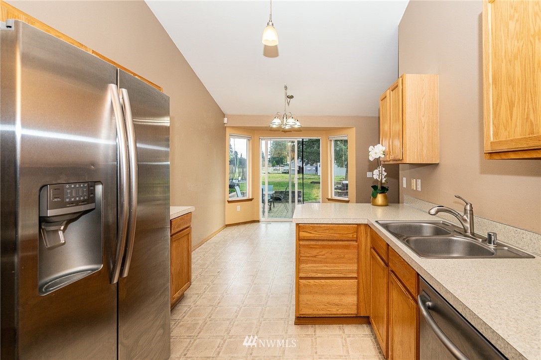18036 Daryl Lane Southwest Rochester, WA 98579 - Photo 25 of 40 a kitchen with stainless steel appliances granite countertop a sink and a refrigerator
