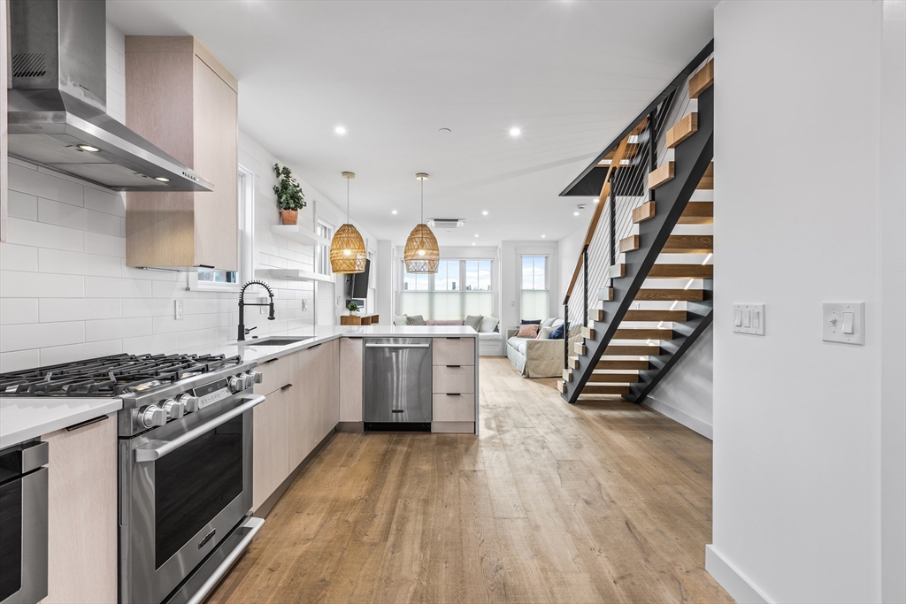 360 Athens Street, Unit 360 Boston, MA 02127 - Photo 6 of 27 a kitchen with granite countertop a stove and a wooden floors