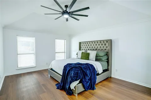 a bedroom with a bed ceiling fan and a window