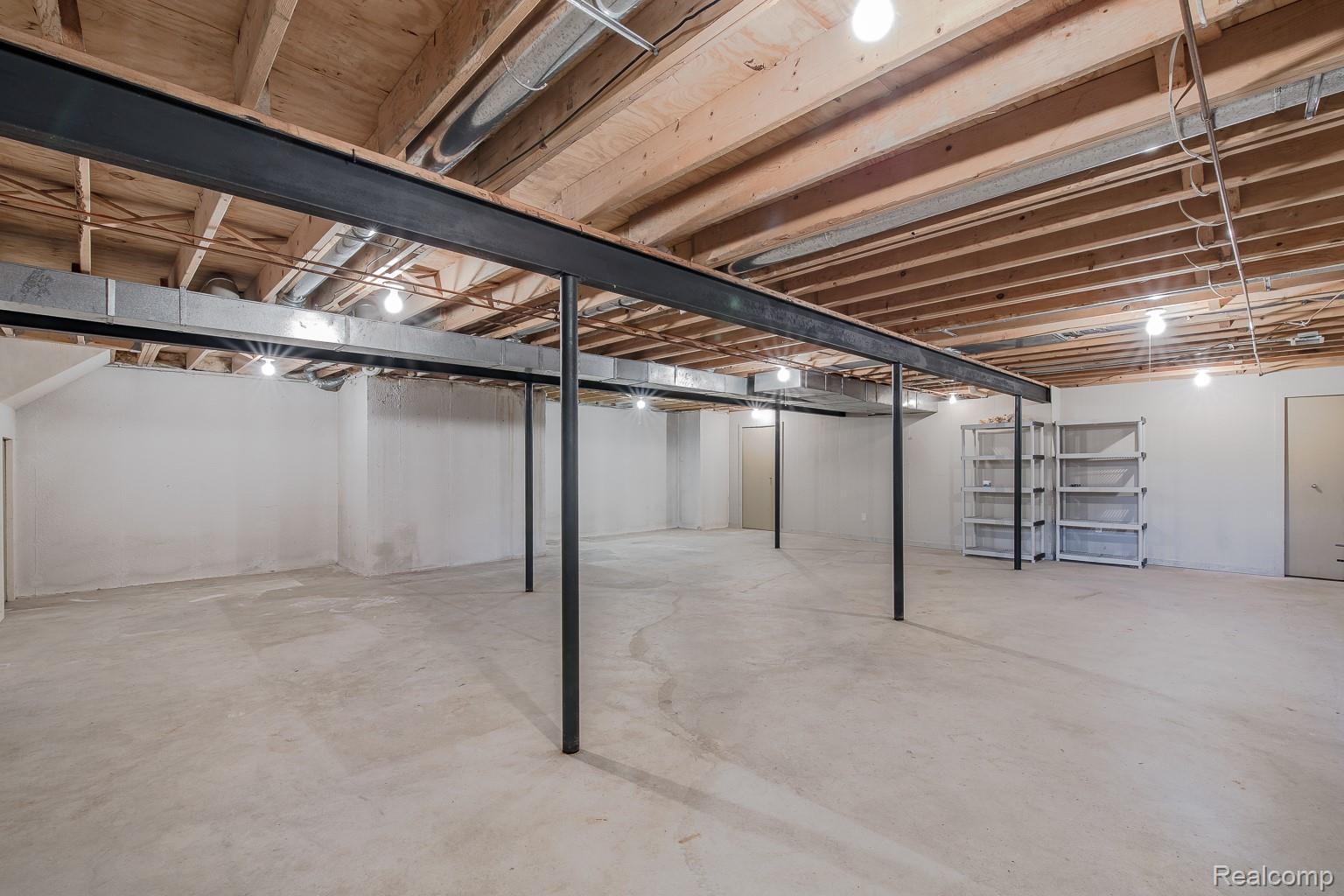 312 Reid Road Highland, MI 48357 - Photo 37 of 47 Spacious unfinished basement featuring exposed wooden joists, concrete flooring, and multiple support beams
