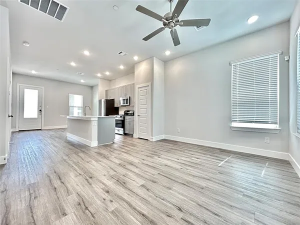 an empty room with a ceiling fan and window