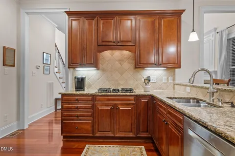 a kitchen with stainless steel appliances granite countertop a sink stove and cabinets