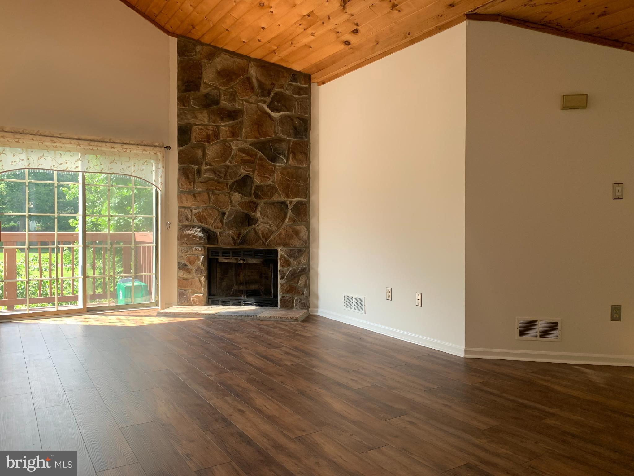 214 Christopher Place, Unit 214 Chalfont, PA 18914 - Photo 6 of 27 an empty room with wooden floor and fireplace
