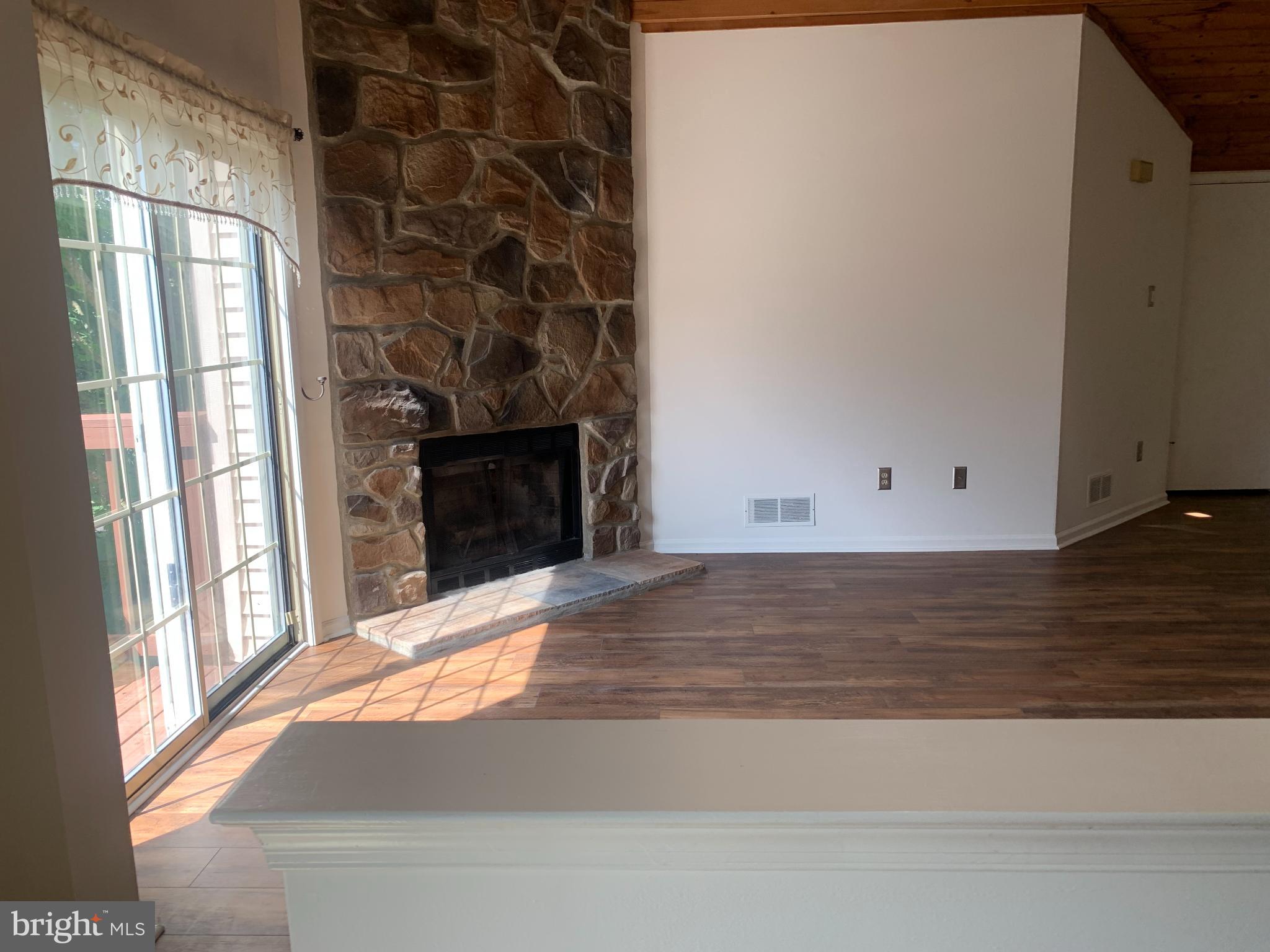 214 Christopher Place, Unit 214 Chalfont, PA 18914 - Photo 8 of 27 a view of an empty room with wooden floor and a fireplace