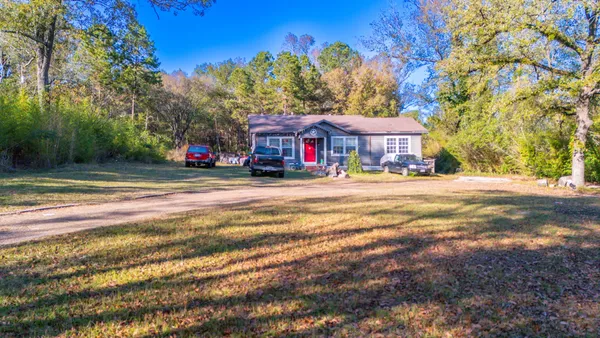 a front view of a house with a yard and trees