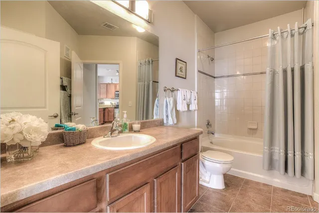 a bathroom with a granite countertop sink a toilet a mirror and bathtub