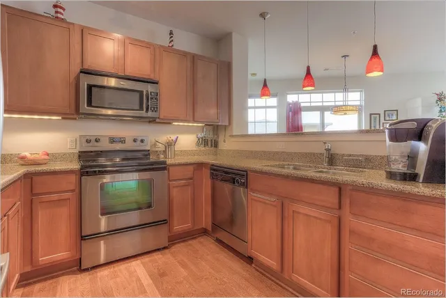 a kitchen with granite countertop a sink stove and microwave