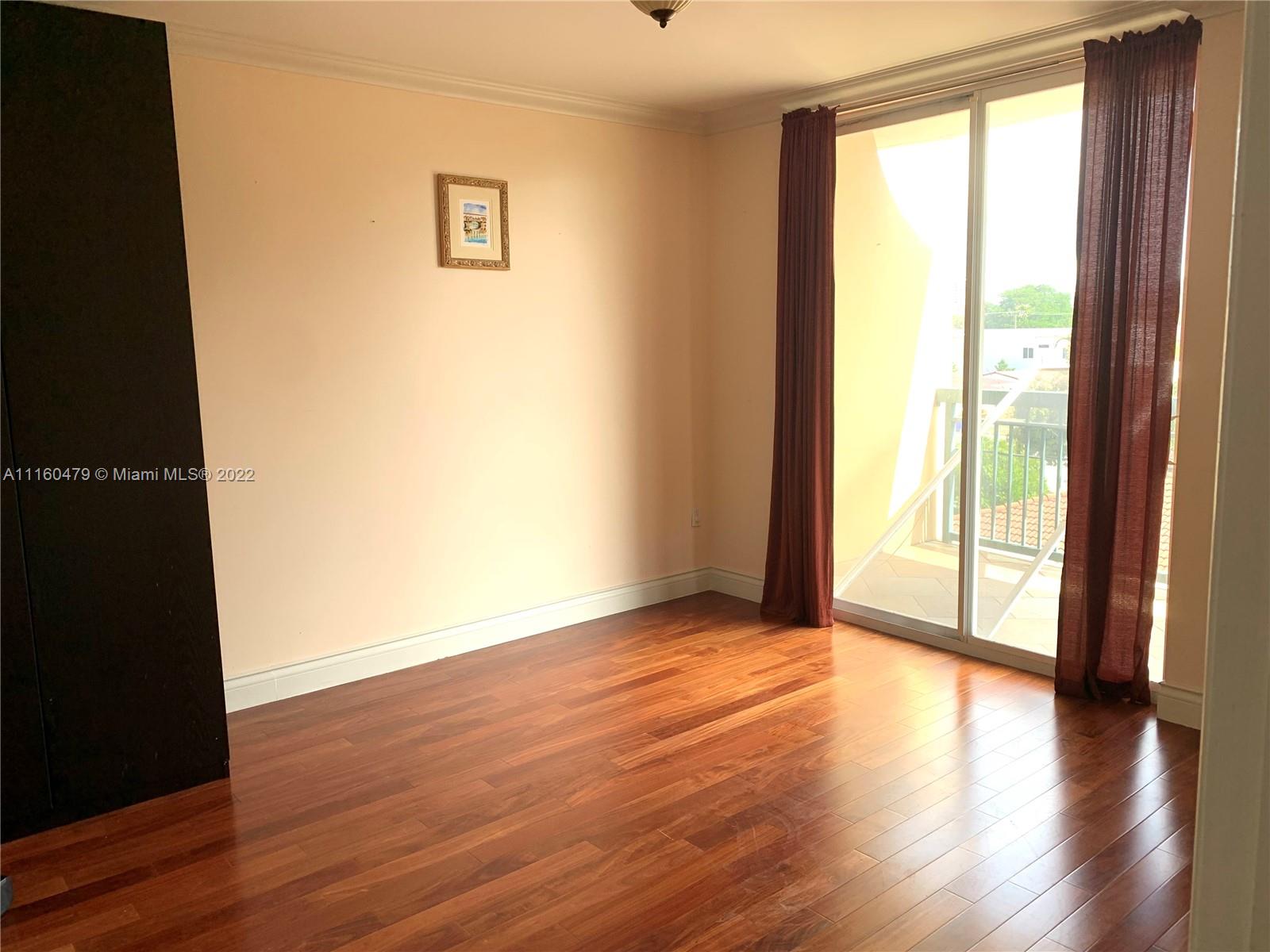 2501 Southwest 37th Avenue, Unit 306 Miami, FL 33133 - Photo 4 of 15 a view of an empty room with wooden floor and a window