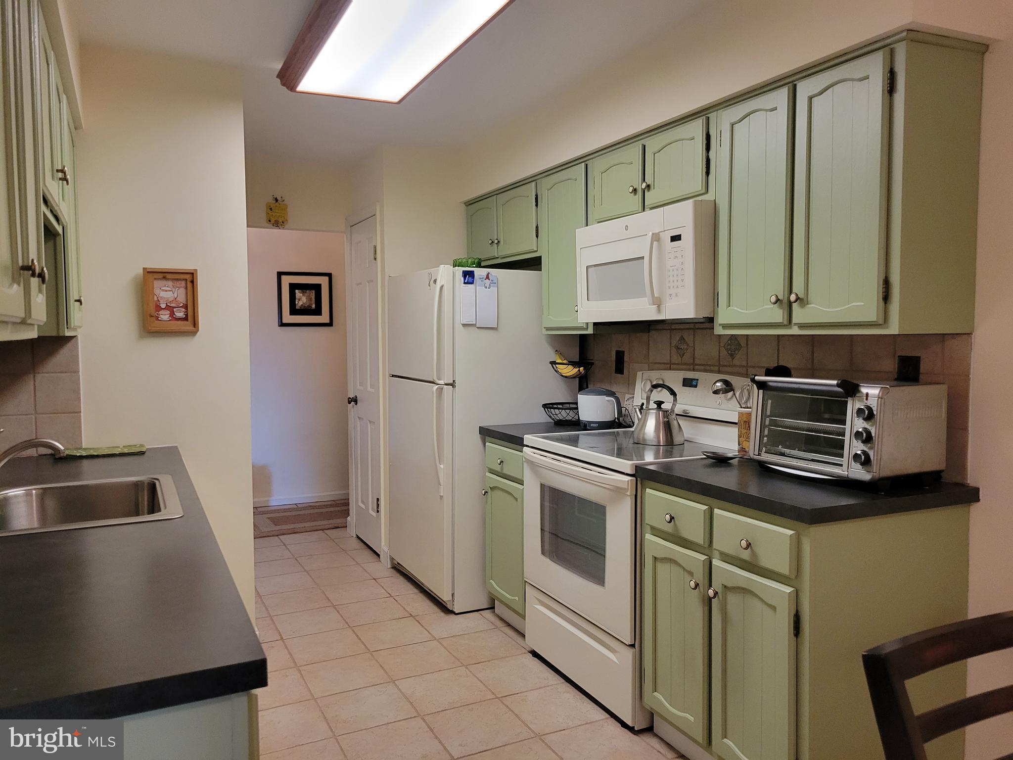 411 Haddonfield Cmns, Unit 411 Haddonfield, NJ 08033 - Photo 14 of 25 More cabinetry, Fridge, Range & Microwave