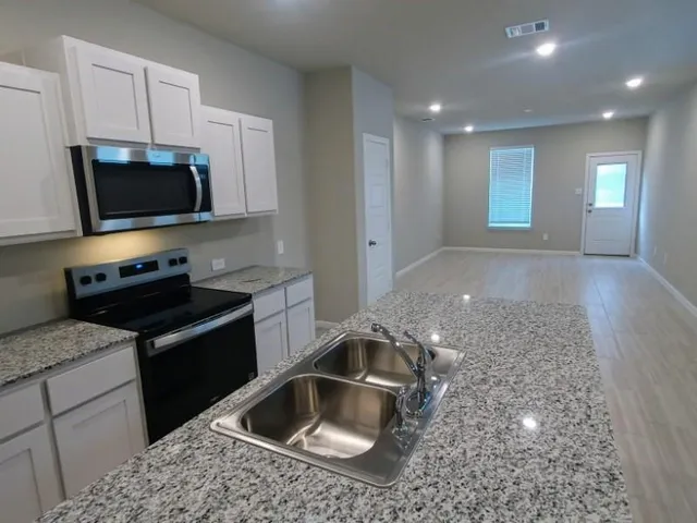 a kitchen with a sink and a stove top oven