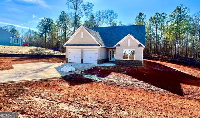 a front view of a house with a yard and lake view