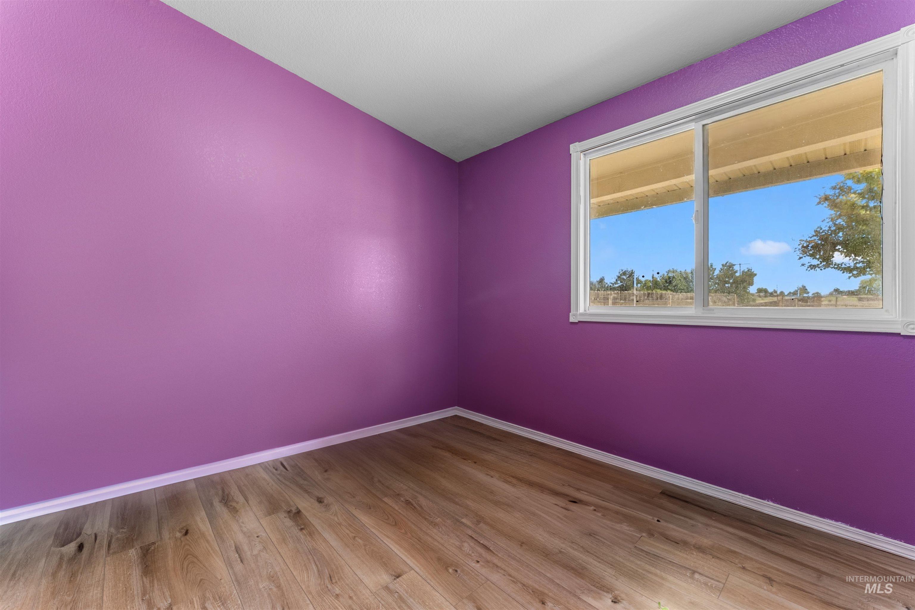 17441 Upper Pleasant Ridge Road Caldwell, ID 83607 - Photo 19 of 40 Bright interior space featuring a window with white trim, wood-finish flooring, and white baseboards
