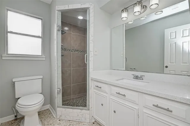 a spacious bathroom with a shower sink and mirror