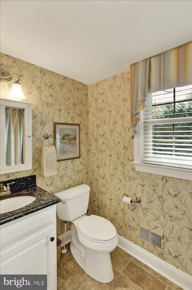 2 Cardinal Road Wyomissing, PA 19610 - Photo 37 of 51 a bathroom with a granite countertop toilet a sink a mirror and a window
