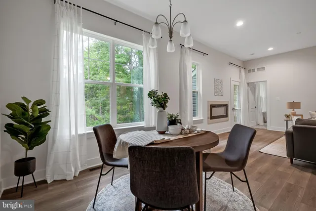 a dining room with furniture potted plants and wooden floor