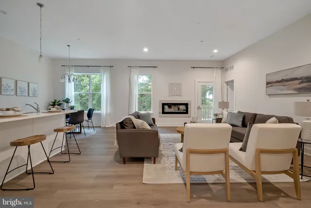 a living room with fireplace furniture and a large window