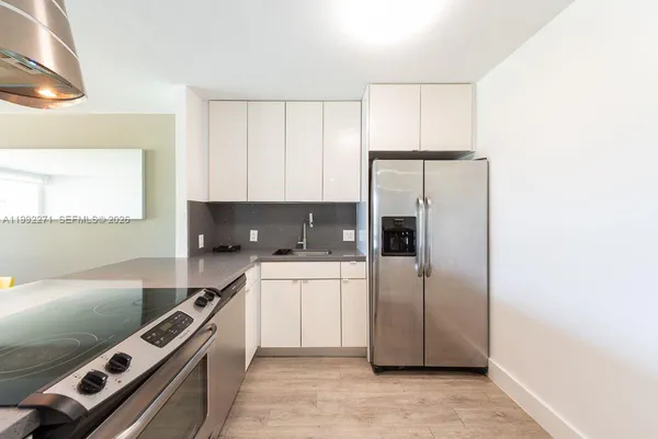 a kitchen with a refrigerator a stove a microwave and cabinets