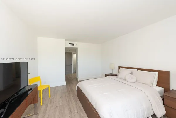 a bedroom with a bed and a flat screen tv