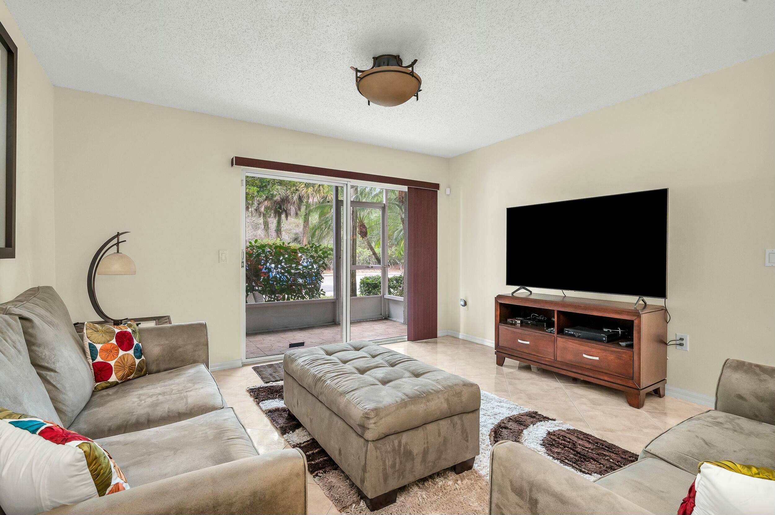 5031 Wiles Road, Unit 107 Coconut Creek, FL 33073 - Photo 15 of 22 a living room with furniture and a flat screen tv