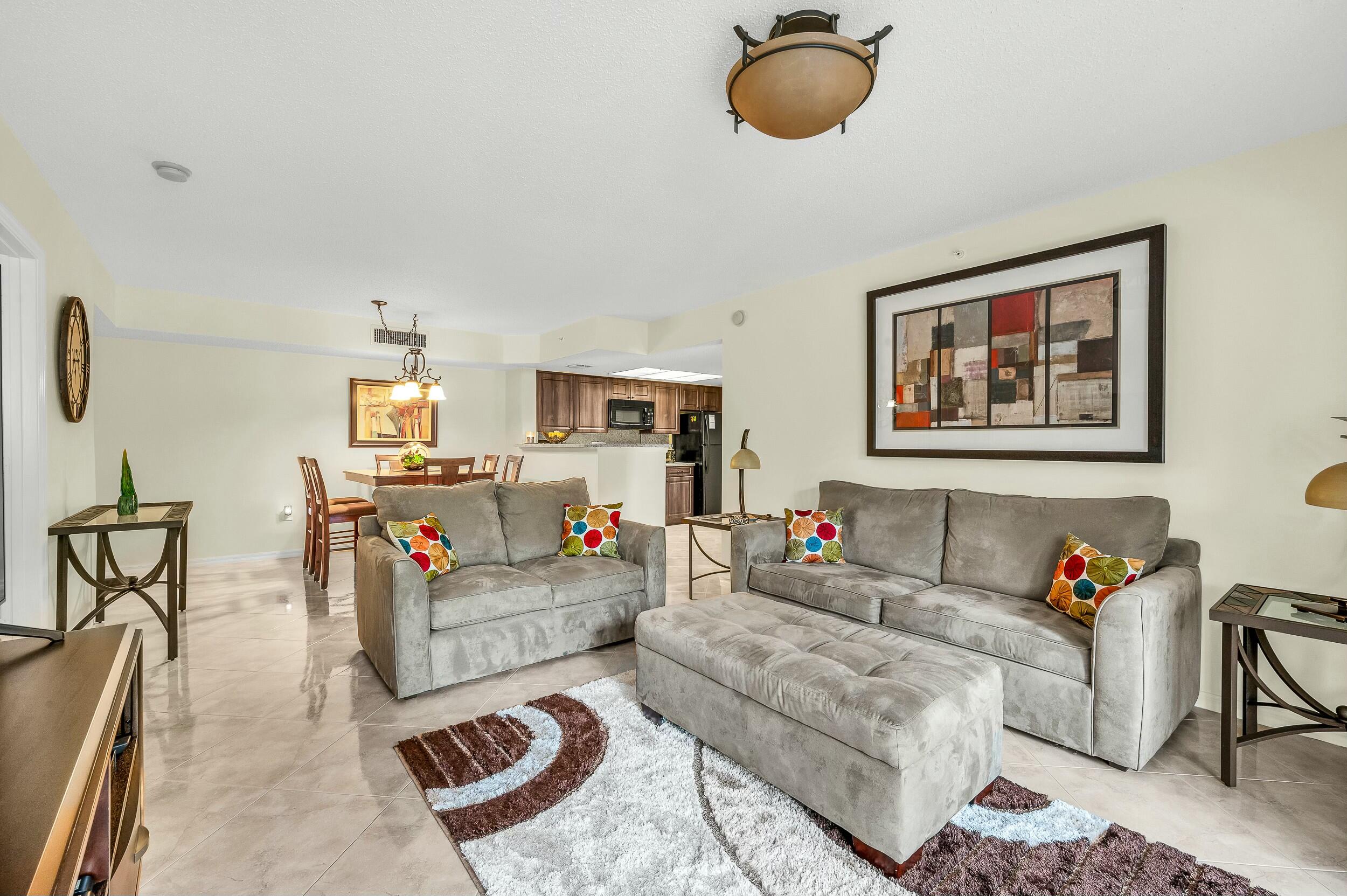 5031 Wiles Road, Unit 107 Coconut Creek, FL 33073 - Photo 17 of 22 a living room with furniture and a chandelier
