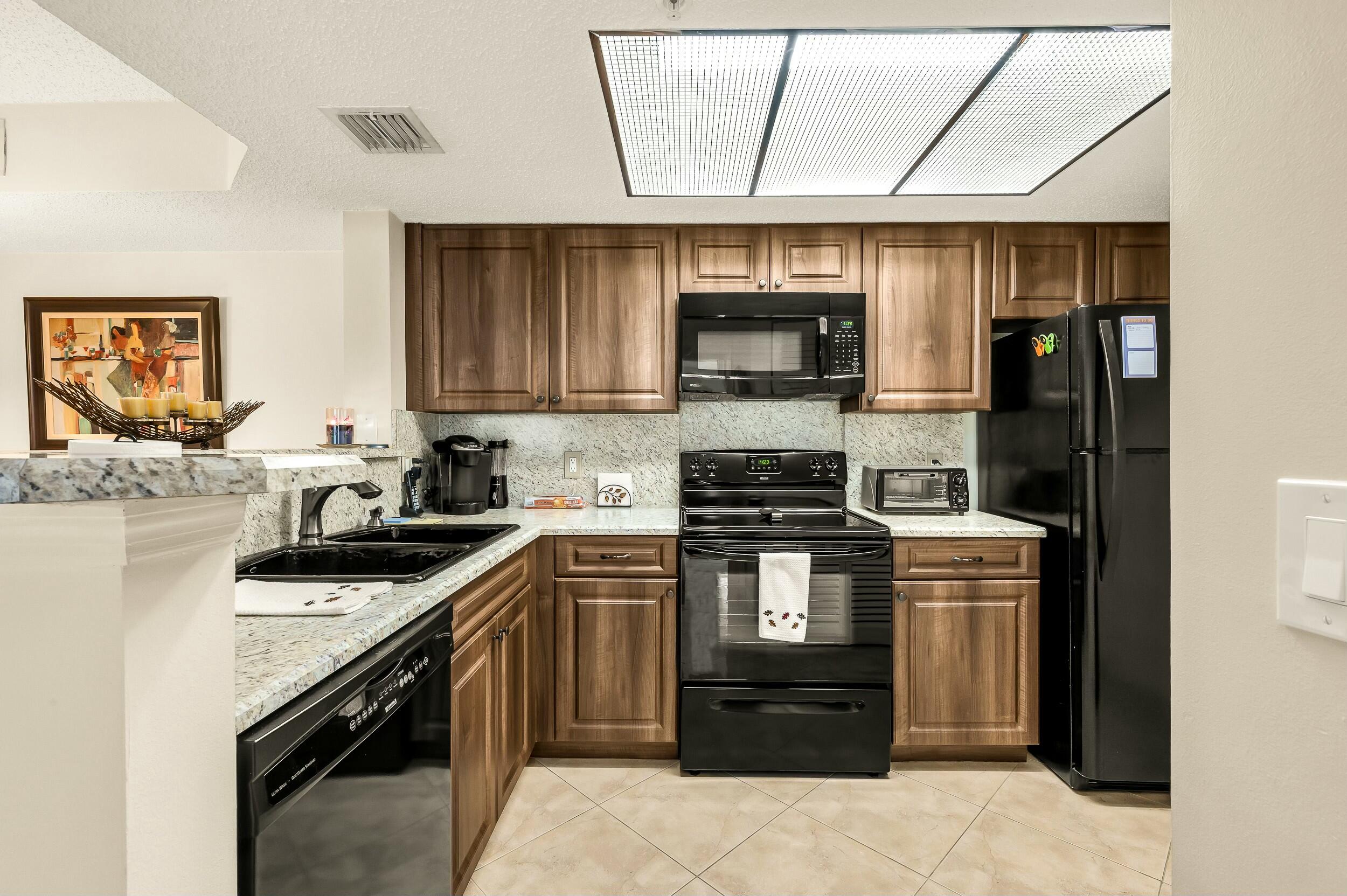 5031 Wiles Road, Unit 107 Coconut Creek, FL 33073 - Photo 18 of 22 a kitchen with a sink stove and microwave