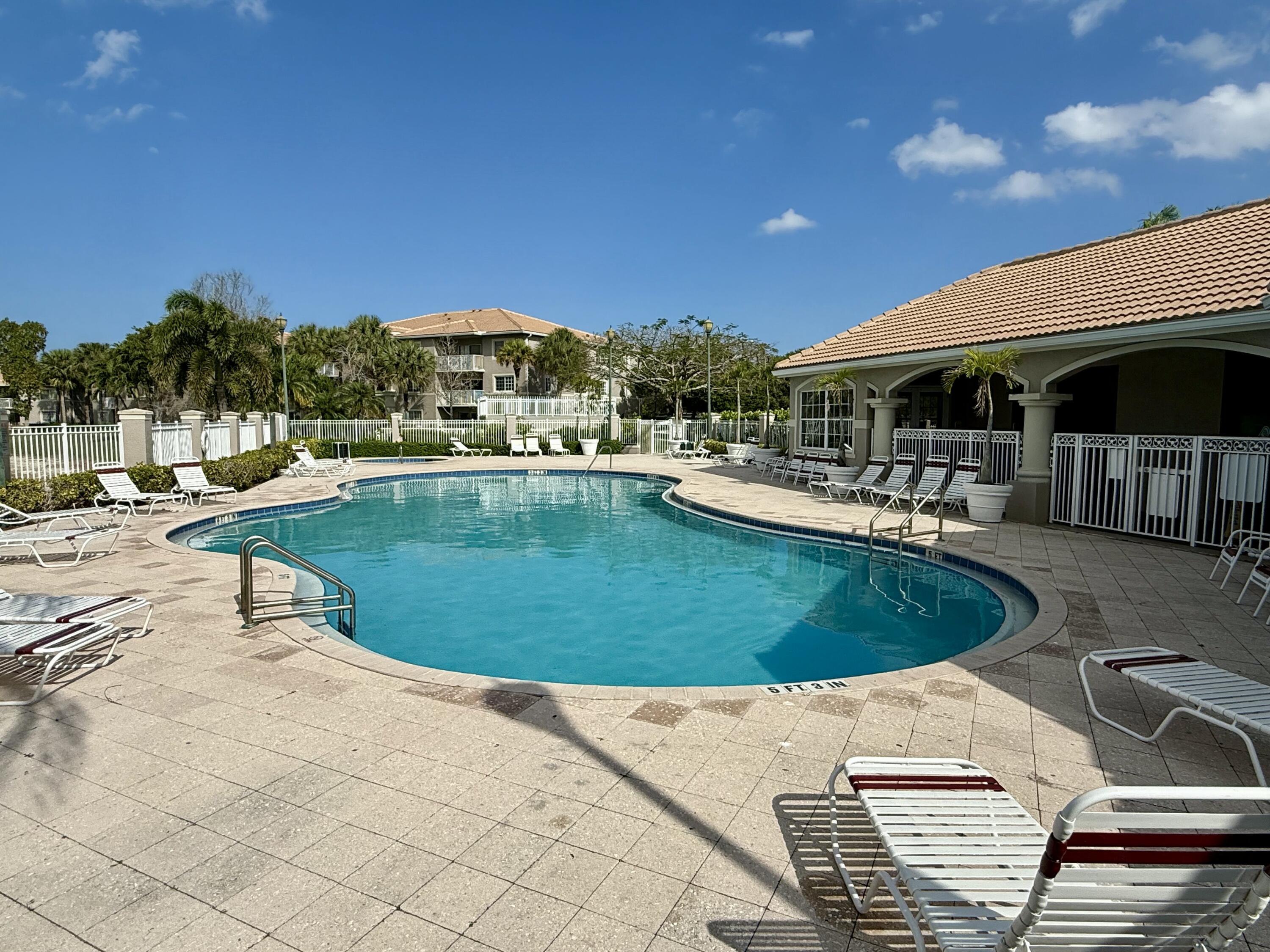 5031 Wiles Road, Unit 107 Coconut Creek, FL 33073 - Photo 21 of 22 a view of a swimming pool with chairs