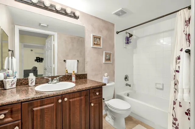 a bathroom with a granite countertop sink toilet and shower